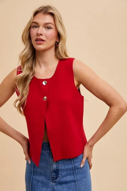 Chic red crop sweater vest featuring sleeveless design and stylish metal button accents for a polished look.