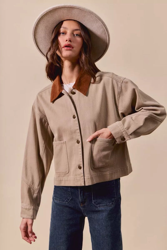 Model wearing Suri Cotton Twill Cropped Barn Jacket in Taupe with collared neckline and button front.