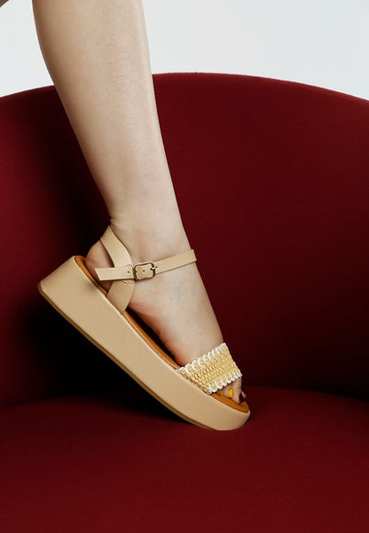 Side view of beige raffia summer sandals with open toe, pin buckle closure, and cushion insole.