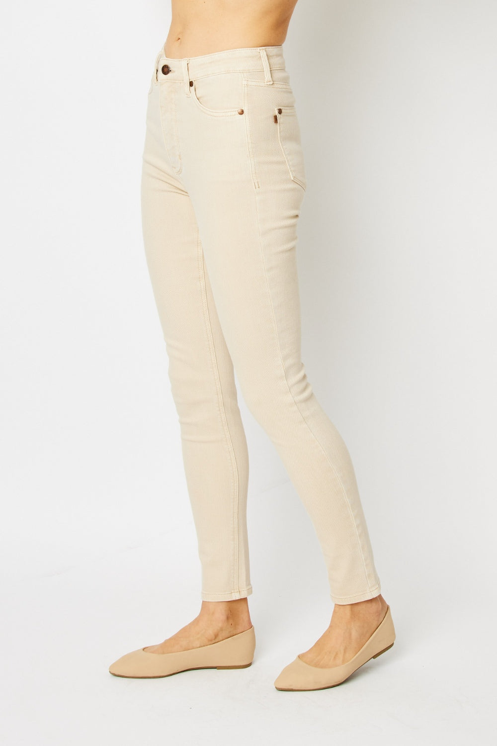 High-rise skinny jeans in bone with tummy control panel and zip fly. Slightly stretchy for comfort.