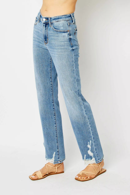 Side angle of plus size Judy Blue Estee medium wash straight jeans with raw hem and destroy.