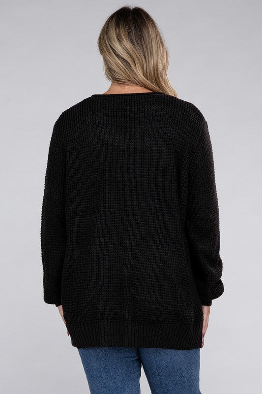 Curvy plus-size waffle-pattern open cardigan sweater in black, with long sleeves, oversized fit, and pockets.