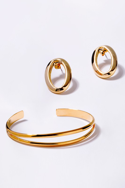 Gold oval earrings and a matching cuff bracelet.