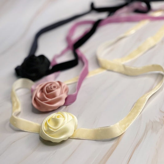 Satin Rose Velvet Sash Necklaces in cream, pink, and black displayed together on flat surface