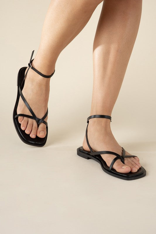 Black stylish strappy flat sandals with an open toe and square shape.