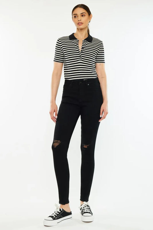 Full body front view of Vesper black distressed high rise skinny jeans styled with a polo shirt and sneakers for a casual, edgy look.