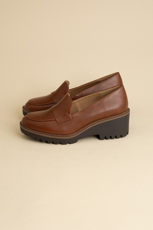 Chunky loafers in cognac feature a sleek design with a 2.3" heel.