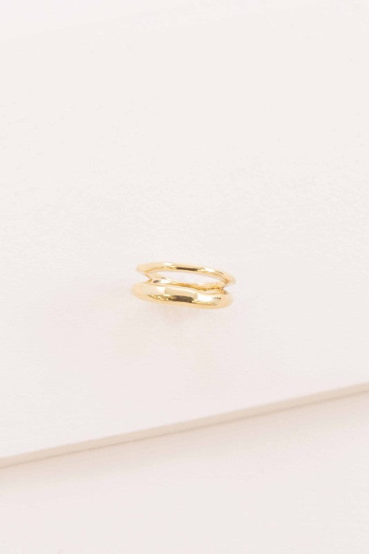 Double Layer Ring in polished gold on flat surface.
