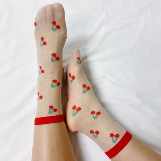 Woman wearing red cherry Sweet & Fruity Sheer Socks with playful fruit design and sheer lightweight fabric.