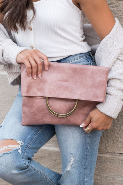 Blush Safara Fold-Over Clutch with antique bronze double O-ring detail and vegan leather finish.