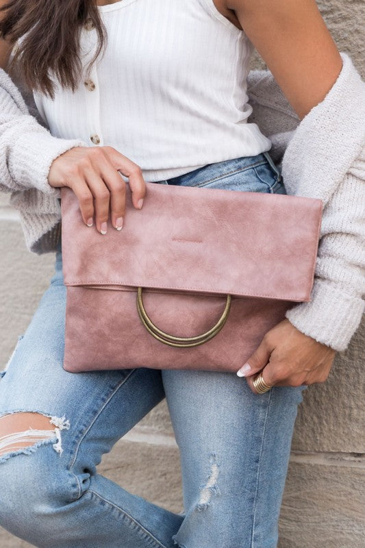 Blush Safara Fold-Over Clutch with antique bronze double O-ring detail and vegan leather finish.