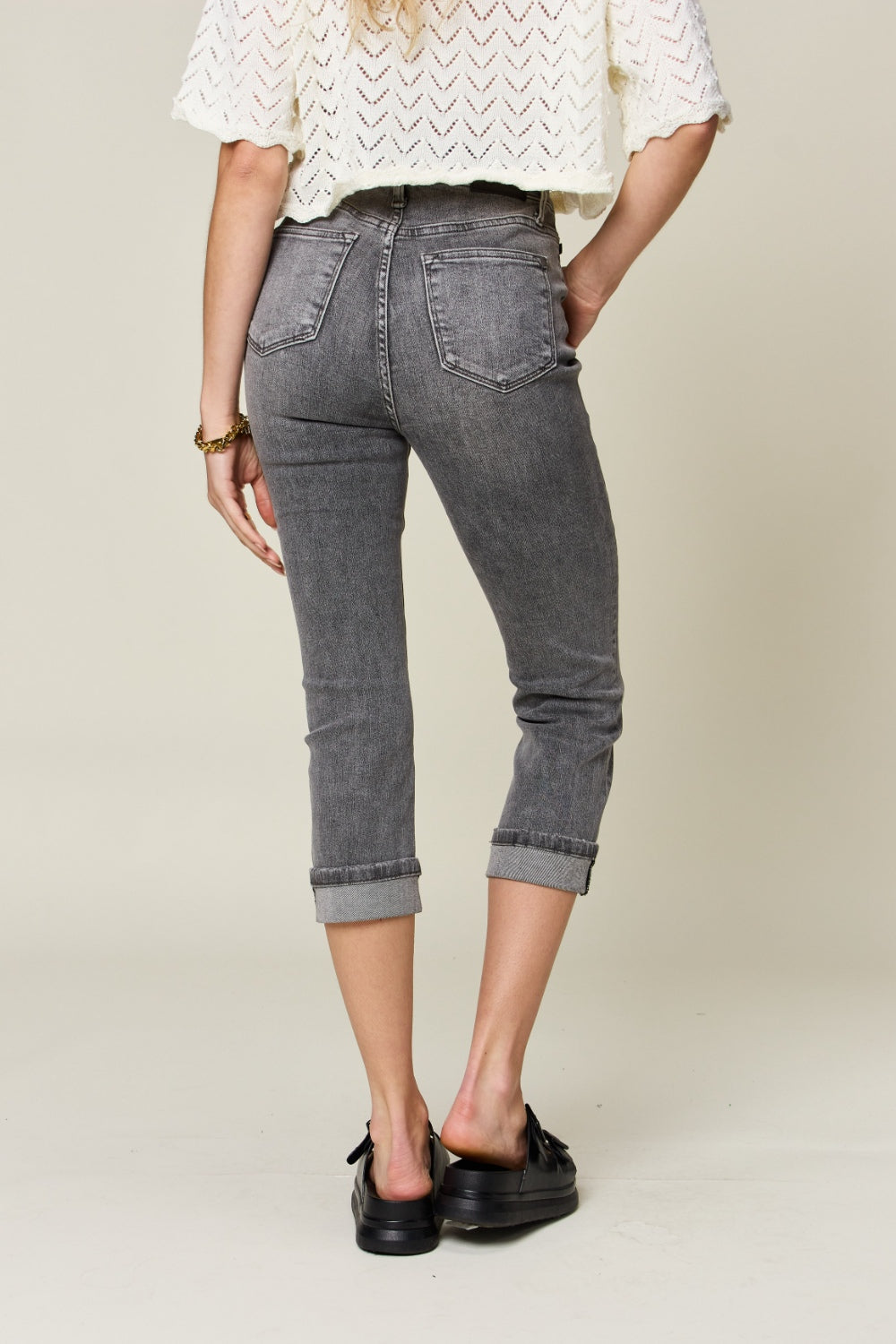 Button fly high waist cuffed capris in gray feature a high waist, button fly, and cuffed hem. Made with slightly stretchy material.