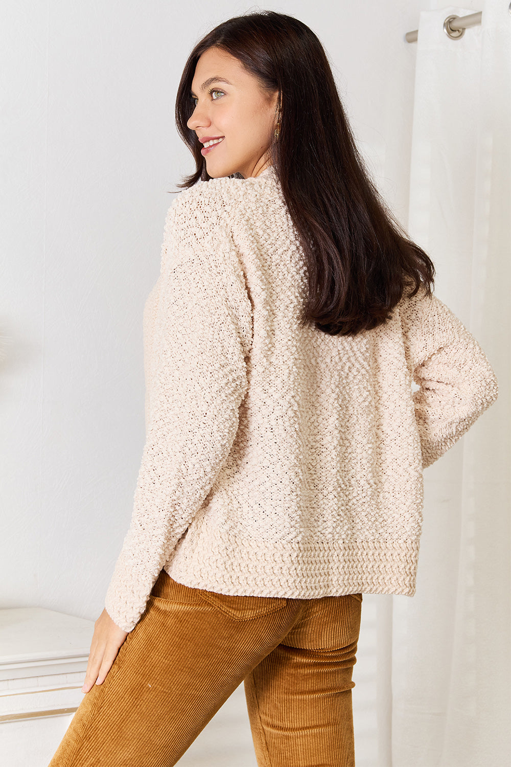 Cream open front cardigan with long sleeves.