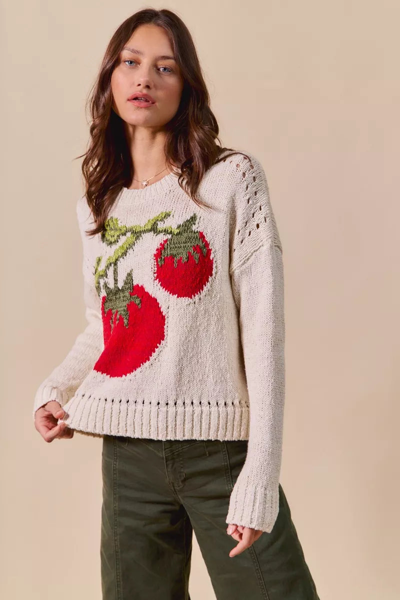Model styling Tara Tomato Sweater with jeans, cream knit with quirky tomato motif