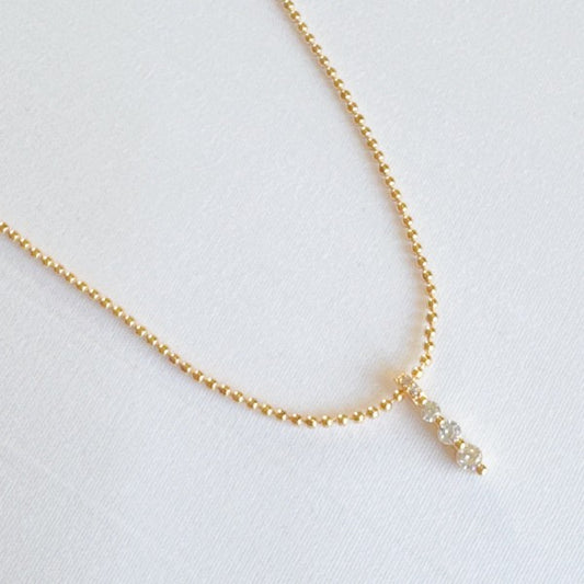 Flat lay of Three Sparkles Necklace with gold chain and three crystal drops