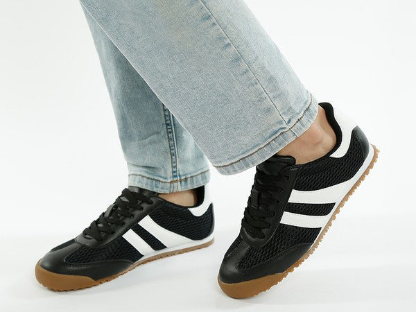 Alternate side angle of model wearing black Blaster lace-up sneakers with white contrast stripes and mesh upper – sporty and casual look