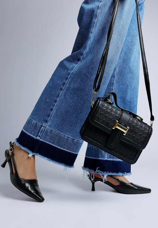 Model walking in Luxton Slingback Pin Buckle Kitten Heels in Black paired with wide-leg jeans and handbag