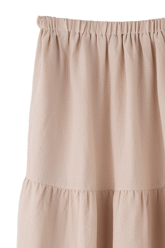 Tiered maxi skirt with elastic waistband in beige. Flowy silhouett, lined for full coverage.