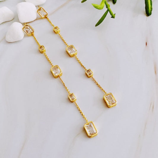 Clear Five Stones Dangle Drop Earrings flat lay on marble background