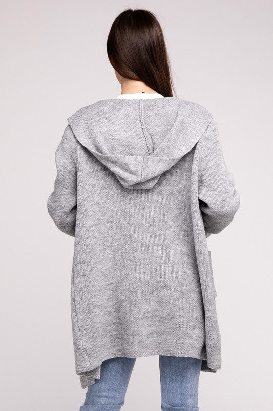 Grey sweater cardigan with long sleeves, front pockets, and a hooded neckline. 