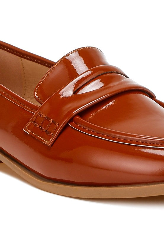 Close-up of Brown Avery Patent Loafers highlighting penny strap and polished patent texture.