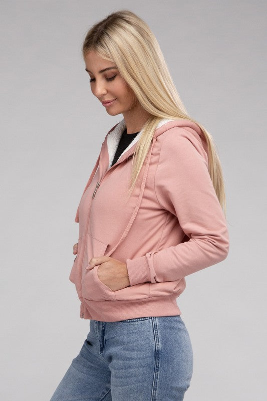 Mauve cropped zip-up hoodie with fuzzy trim, pockets, and long sleeves.