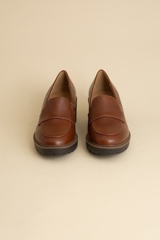 Chunky loafers in cognac feature a sleek design with a 2.3" heel.