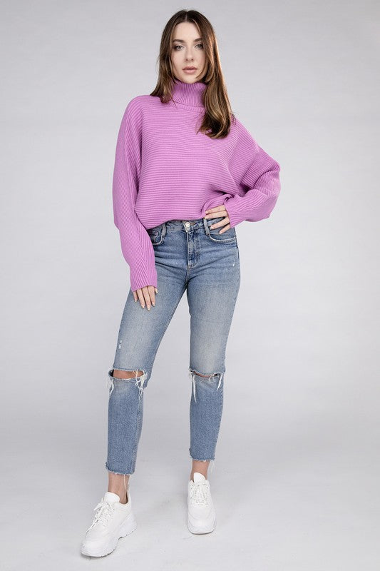 Mauve loose fitting turtleneck sweater, with ribbed knit texture, dolman sleeves, and raw hem detailing.