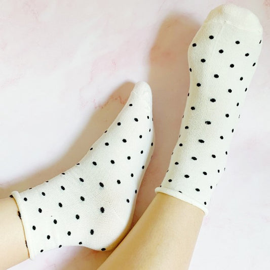 Woman wearing cream Precious Polka Dot Socks with roll-up top and soft cotton blend.