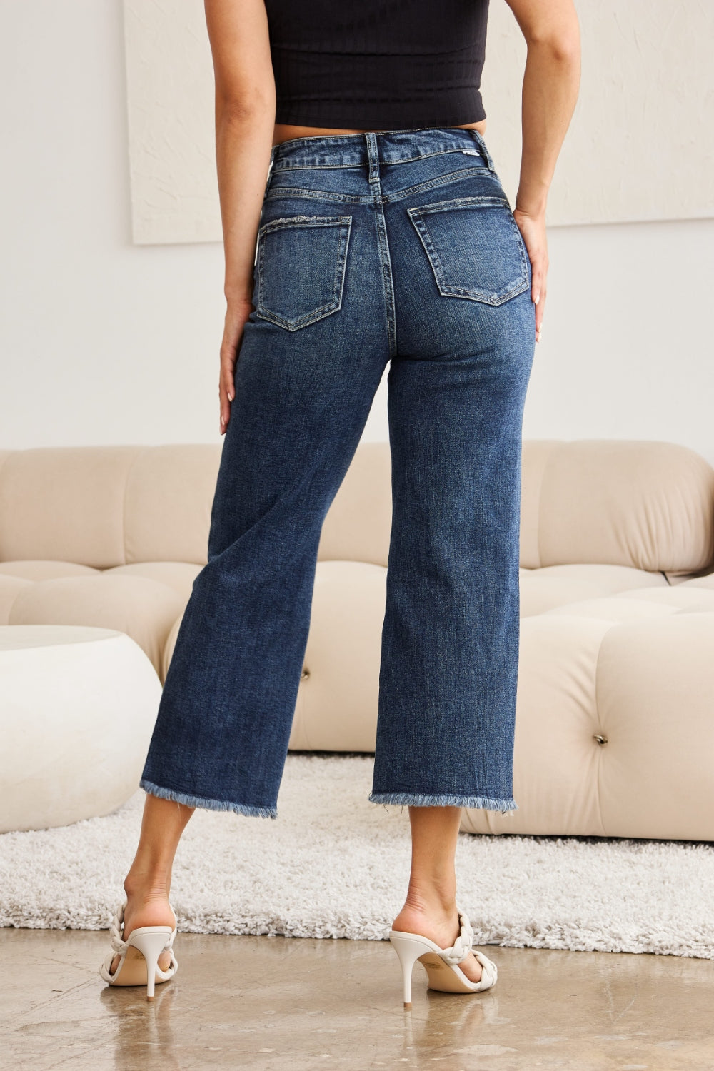 Dark wash high-waisted cropped jeans with tummy control, raw hem, and distressed details