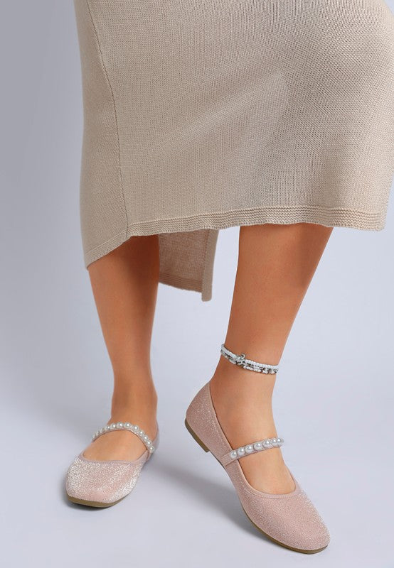 Front view of woman wearing pink Corphee Pearl Strapped Glitter Ballerinas with pearl strap and round toe.