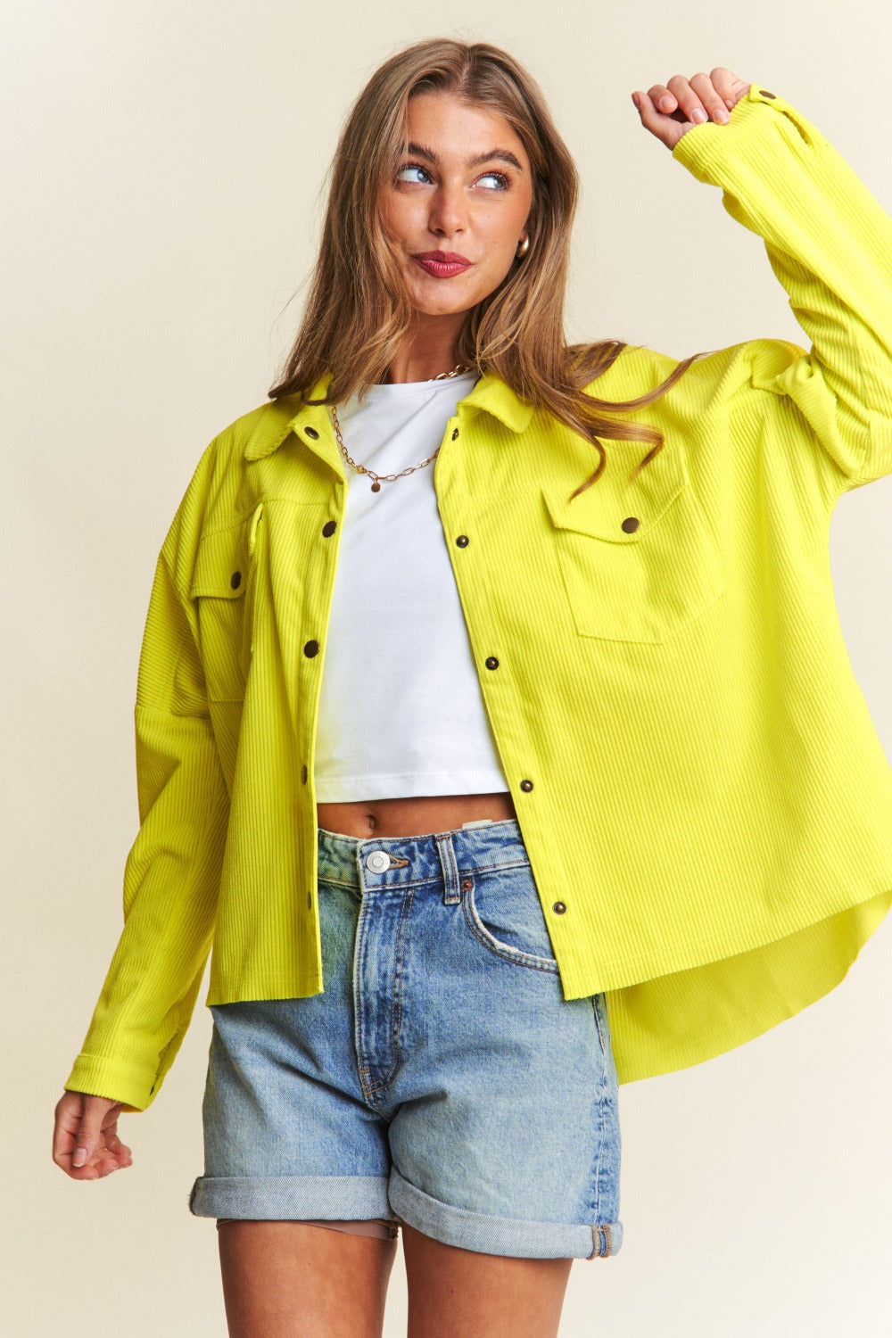 A chartreuse high-low shacket with long sleeves, a collared neckline, and snap-button closure. 