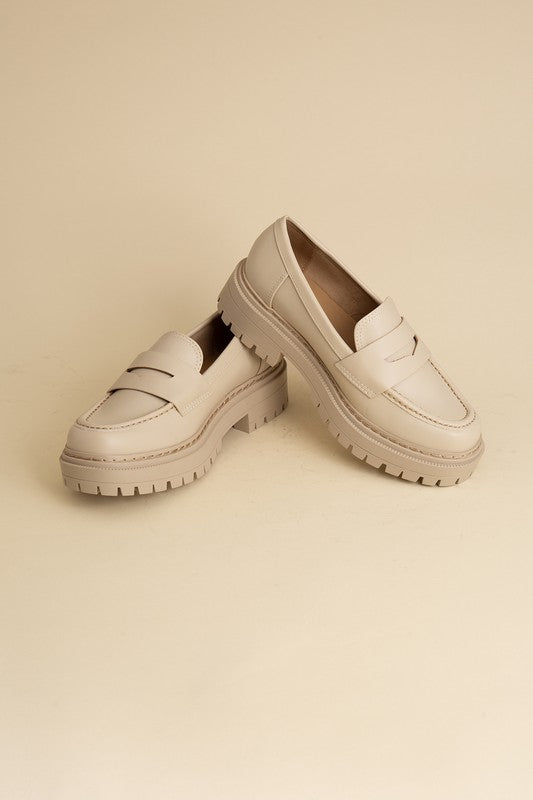 Bone classic loafers with a sleek design and minimalist accents.