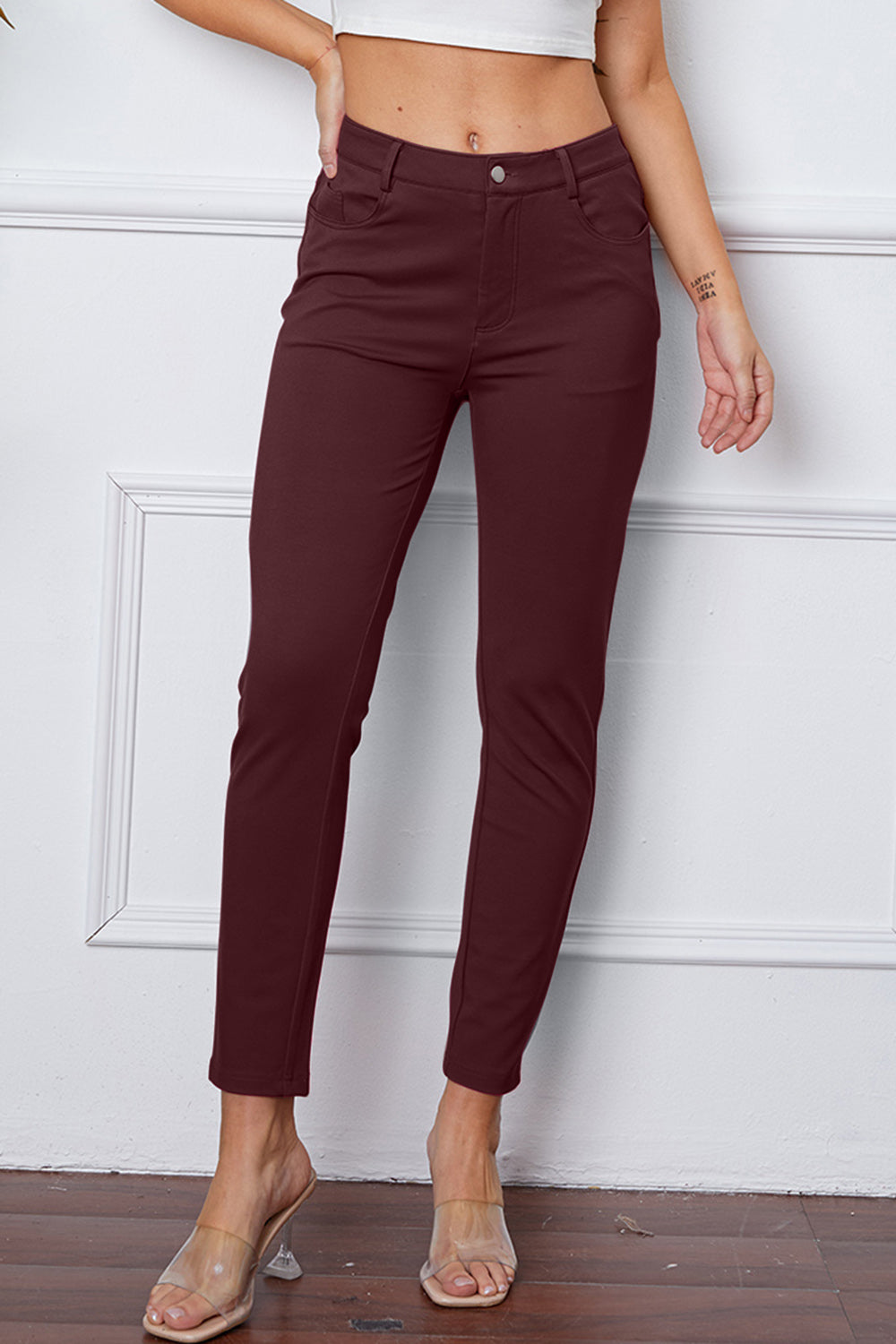 Wine stretchy high-waisted pants feature pockets, a zip fly, and belt loops. 