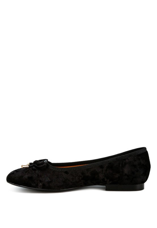 Black velvet ballerina flats with a closed square toe, bow detail on the vamp, and cushioned insoles for comfort.