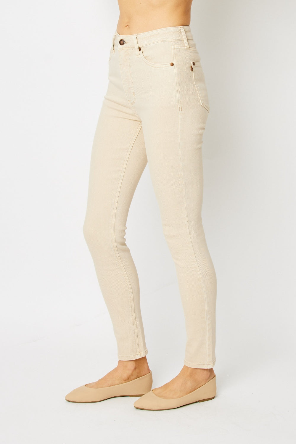 High-rise skinny jeans in bone with tummy control panel and zip fly. Slightly stretchy for comfort.