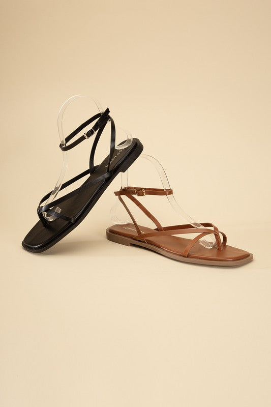 Black and Tan stylish strappy flat sandals with an open toe and square shape.