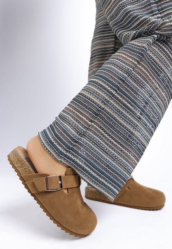 Model wearing Tan Ratiha Mules showing lateral side view with buckle strap and cushioned insole.