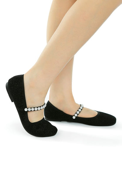 Side view of woman wearing black Corphee Pearl Strapped Glitter Ballerinas with flexible sole and cushioned insole.