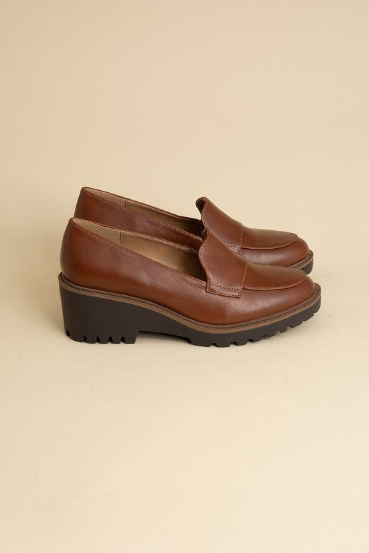 Chunky loafers in cognac feature a sleek design with a 2.3" heel.