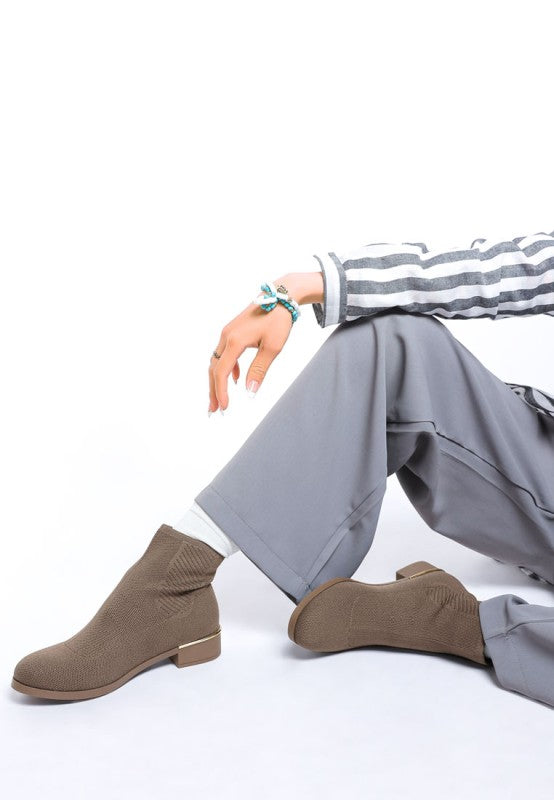 Side front pose in taupe Rosamund Sock Boots with round toe and paneling.