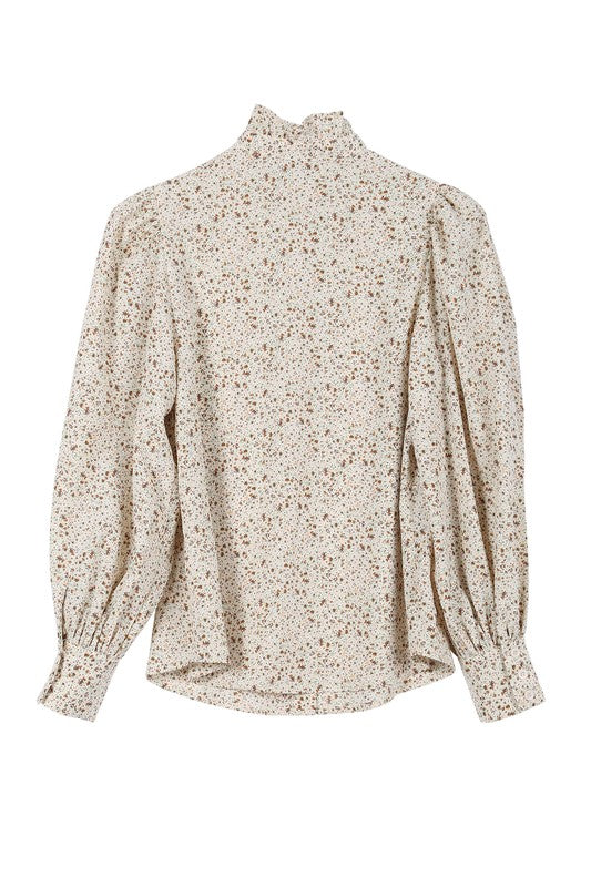 Stand Collar Floral Frill Blouse with puff long sleeves, floral pattern, and ruffled front detailing. Features shirring at the collar, shoulders, and cuffs. Button down closure.