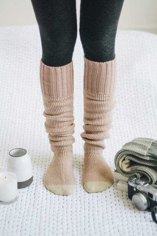 Woman standing in pink Jerica Lounge Socks, knee-high oversized lounge style.