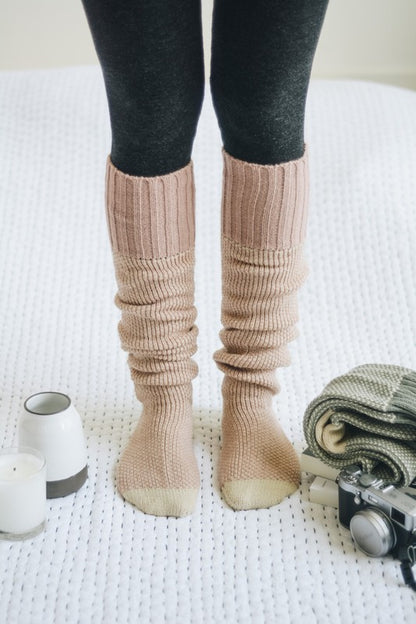 Woman standing in pink Jerica Lounge Socks, knee-high oversized lounge style.