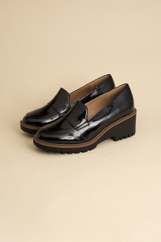 Chunky loafers in black feature a sleek design with a 2.3" heel.