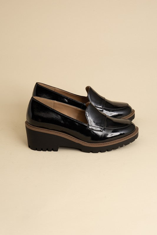 Chunky loafers in black feature a sleek design with a 2.3" heel.