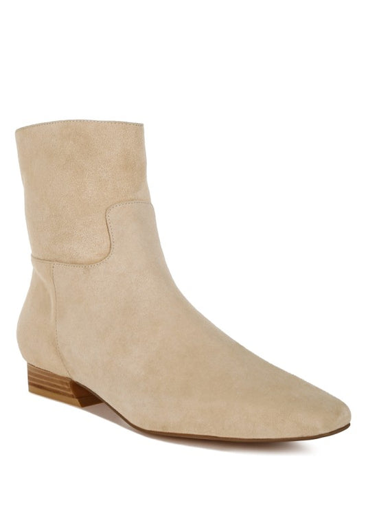 Front angle view of beige Hakra suede ankle boots with flared low block heel and snip toe design.