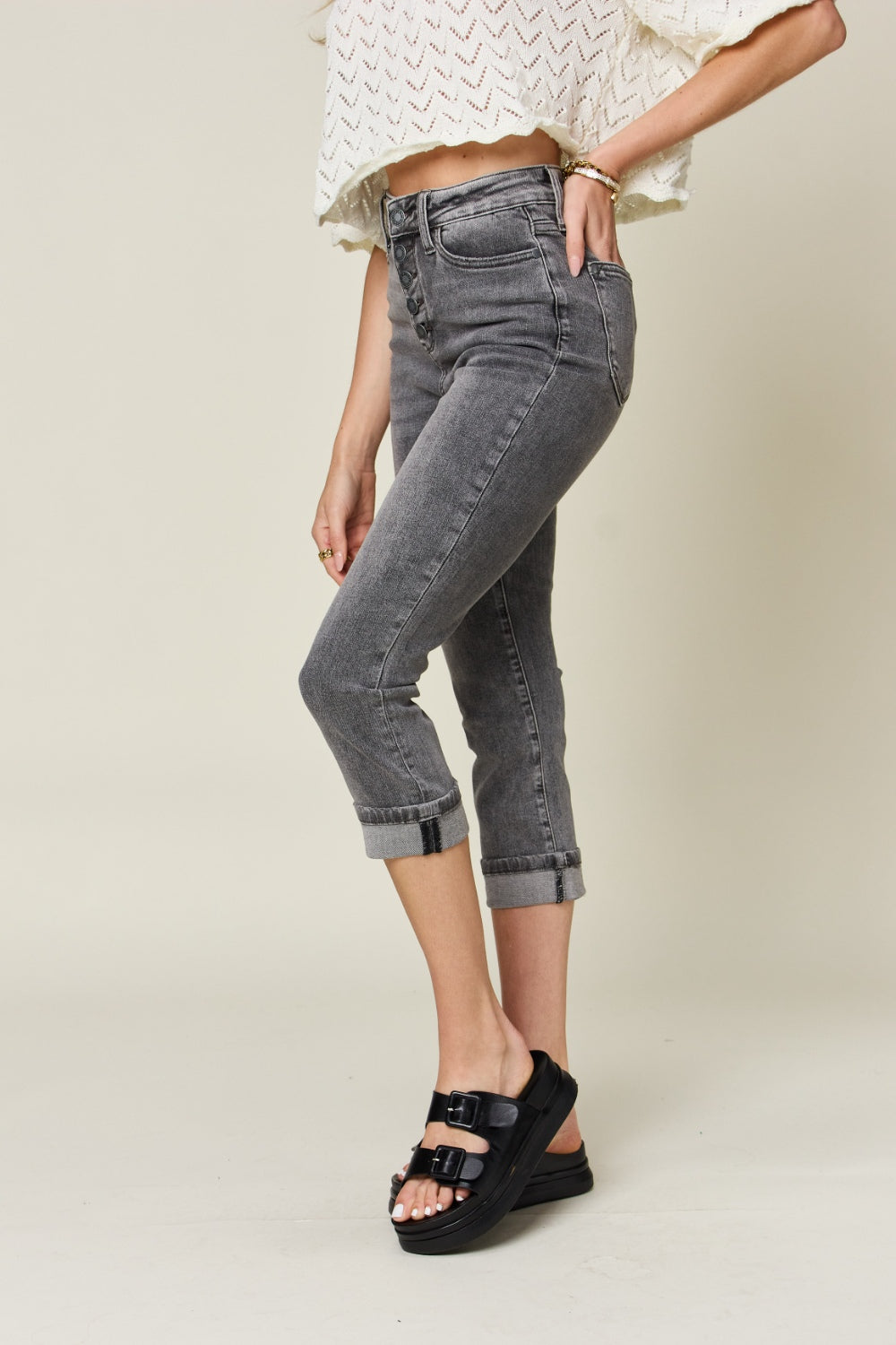 Button fly high waist cuffed capris in gray feature a high waist, button fly, and cuffed hem. Made with slightly stretchy material.