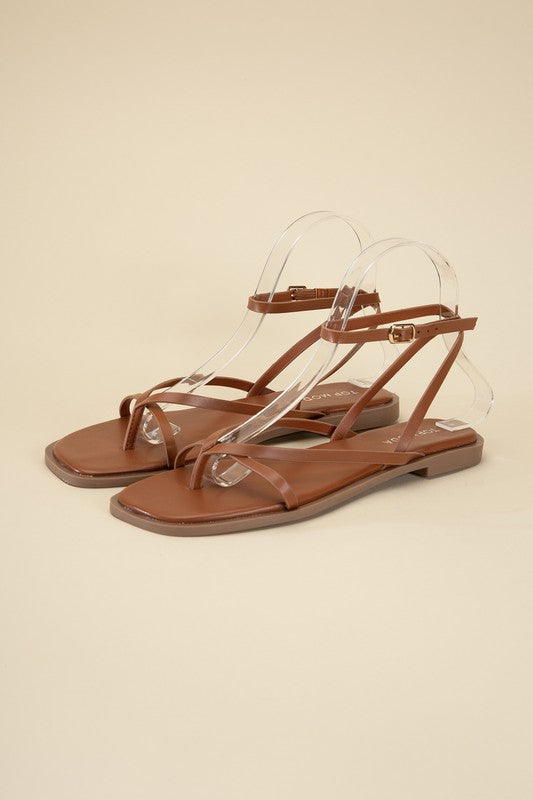 Tan stylish strappy flat sandals with an open toe and square shape.