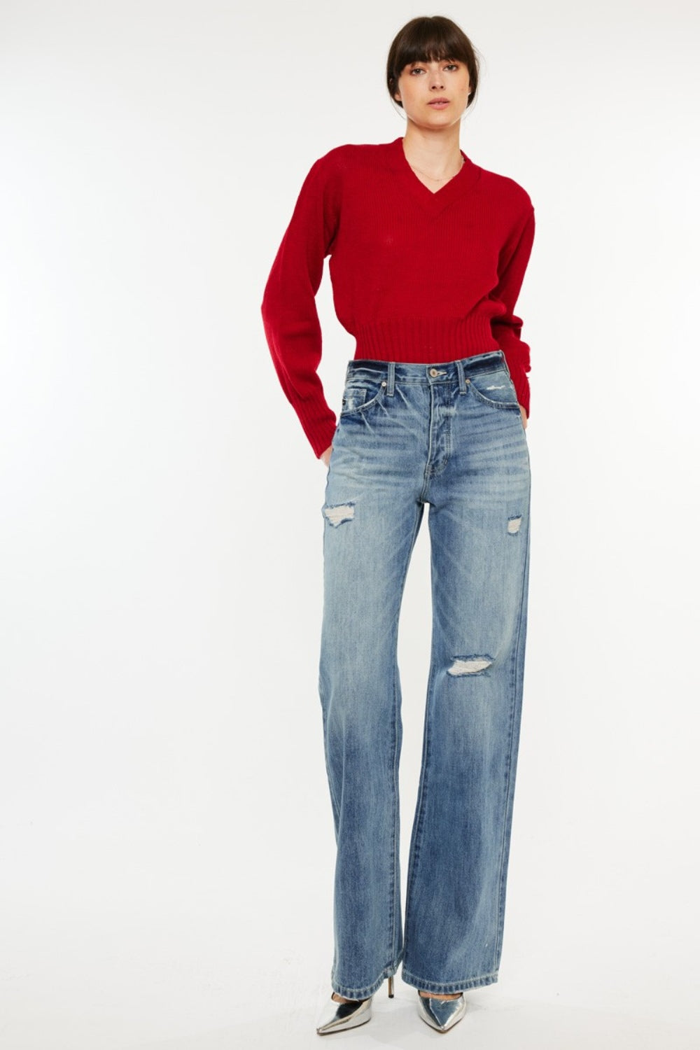 Distressed high-rise bootcut jeans with pockets and a slightly stretchy, washed fabric, offering a retro-chic style.